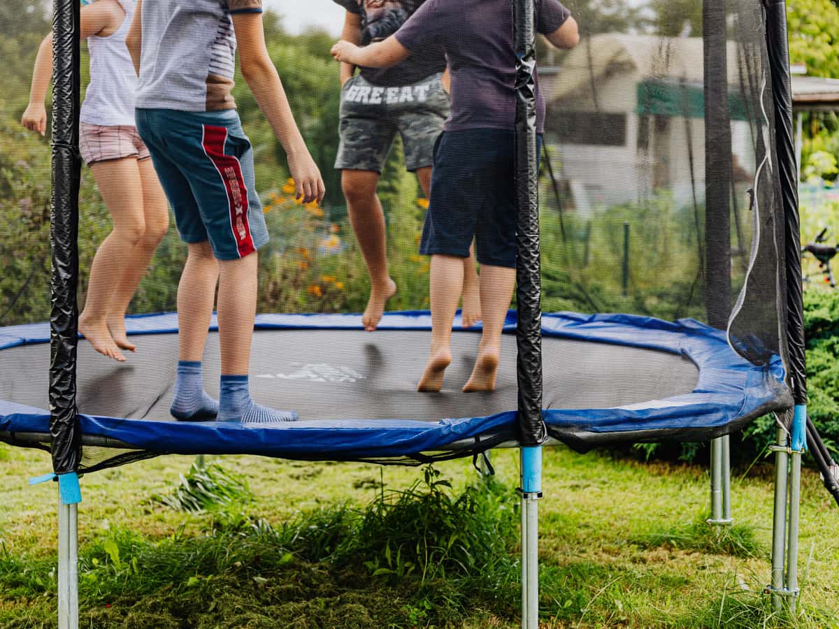 Children jumping on a backyard trampoline — Bounce & Bolt, trampolines, swing sets & backyard play